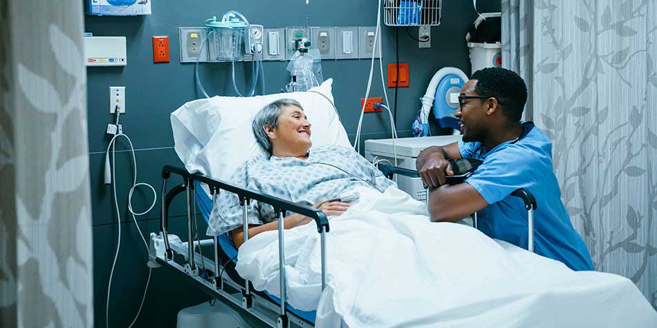 A patient talks to a hospital colleague from her hospital bed.